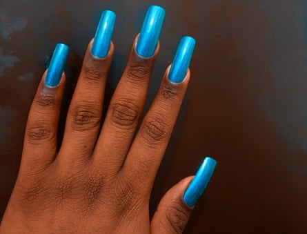 A hand with very long, blue-painted nails