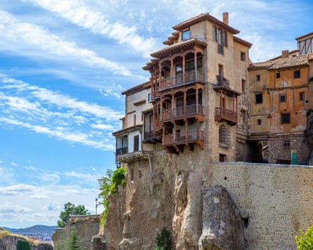 Old buildings perched on a cliff under blue skills