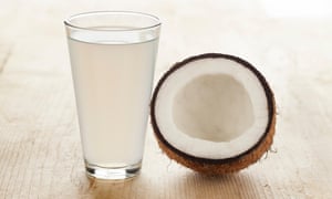 a halved coconut and coconut water in a glass