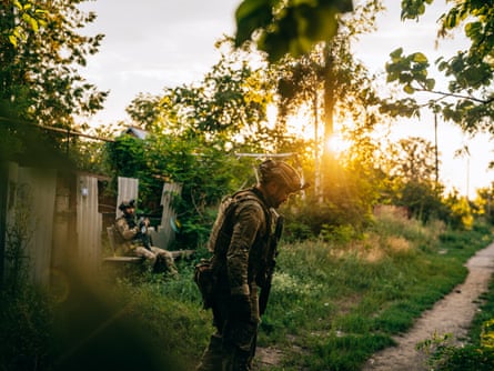 A soldier looks down at the ground.
