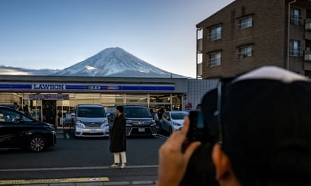 screen time blocking safari A tourist posing in front of a Lawson convenience store with Mount Fuji in the background, in the town of Fujikawaguchiko, Yamanashi prefecture