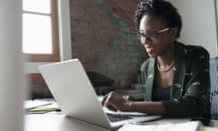 Smiling creative businesswoman working at laptop in office