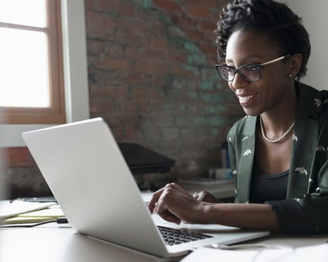Smiling creative businesswoman working at laptop in office
