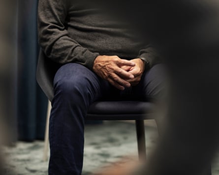 Anonymous man sitting on chair with his hands together