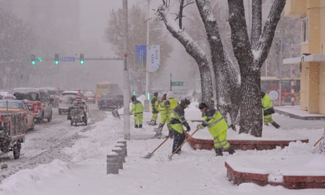 Workers clear snow on a street during a snowstorm on Monday in Harbin, Heilongjiang province.