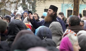An Orthodox priest speaks to demonstrators as they gather to protest against Covid-19 restrictions in Kyiv, Ukraine.