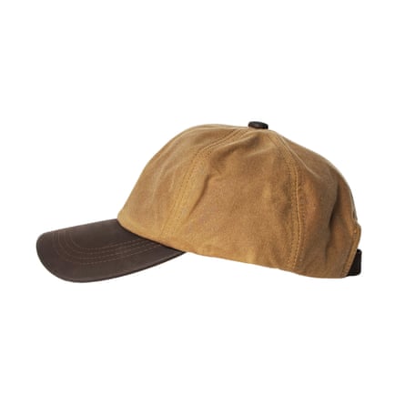 A tan cotton baseball cap with a dark brown leather brim, shown from the side