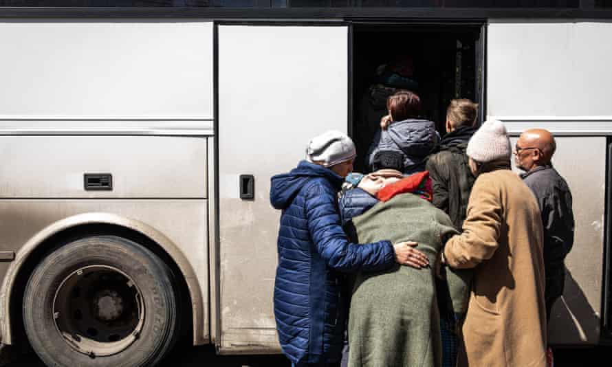 شقيقتان تحملان والدتهما على متن حافلة إجلاء طارئة من منطقة دونباس