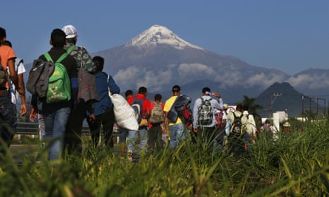 Central American migrants begin their morning trek as part of a thousands-strong caravan hoping to reach the US border, as they face the Pico de Orizaba volcano upon departure from Córdoba, Mexico, on Monday.