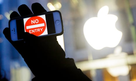 A man holds up an iPhone with a No Entry graphic