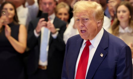 Donald Trump, with a crowd behind him filming him on their phones