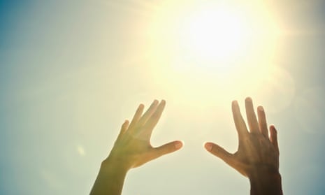 Woman’s hands reaching toward sun