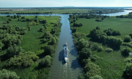 An aerial view of the boat as it moves through green countryside.