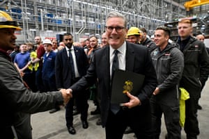 Keir Starmer smiles as he shakes hands with a BAE worker