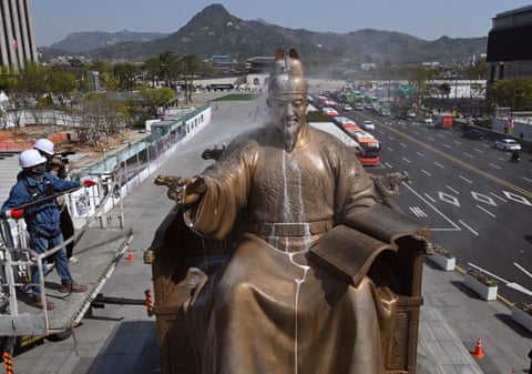 Seoul, South Korea A worker sprays water to wash the bronze statue of King Sejong