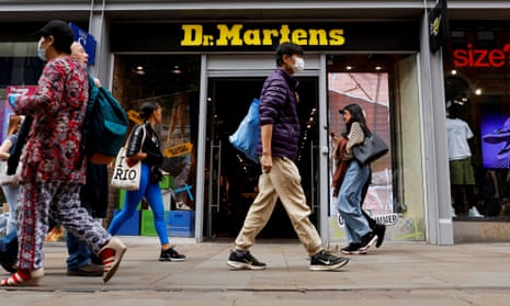 People walk past a Dr. Martens store in Manchester, Britain, May 26, 2023. REUTERS/Jason Cairnduff