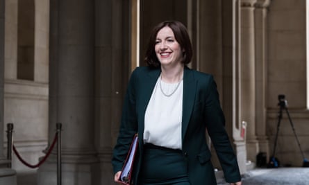 Bridget Phillipson smiling as she walks along holding a ring binder