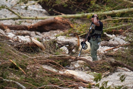 A Sheriff’s deputy pauses while combing through the banks of the Guadalupe River near Camp Mystic.
