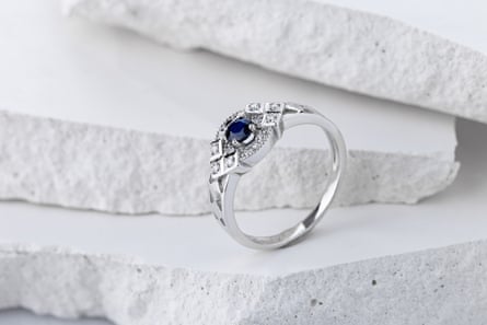 A sapphire and diamond silver ring on a white background.