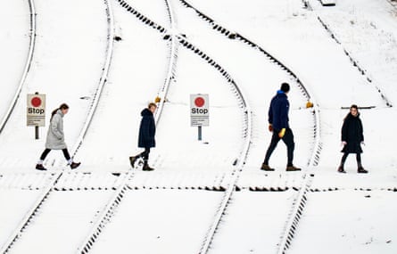 People crossing snowy train tracks in Whitby, Yorkshir
