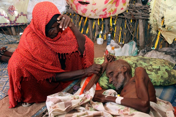 Abdi Ibrahim, who is malnourished, is helped by his wife, Duba Dagane, in Lagbogal, 56km from the town of Wajir in Kenya