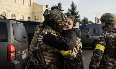 Karina, 14, hugs a Ukrainian soldier at the Kherson train station waiting for the arrival of a train from Kyiv.