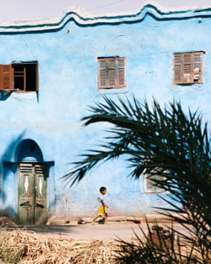 Blue is the colour. A small boy walks in front of a blue-painted house. The cruise takes in all the major sites in upper Egypt, but also life along the riverbank. After visiting the magnificent temple of Ramesseum, dedicated to Pharaoh Ramesses II near Luxor, I went for a walk in a nearby village and fell in love with the colour of the houses.