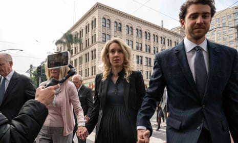 Elizabeth Holmes holding hands outside courthouse with her mother and partner