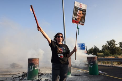 Uma mulher segura um cartaz com a imagem do refém israelense Dror Or, de 43 anos, que foi agora confirmado como morto pelo governo de Israel.