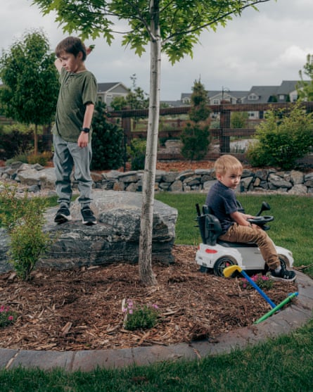 Two boys play in the backyard of a home