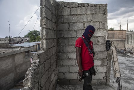 A gang member wearing a balaclava and holding a gun, poses for a photo in the Portail Leogane neighbourhood of Port-au-Prince, Haiti.