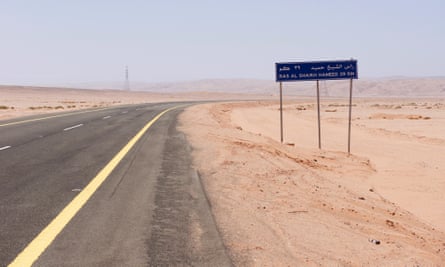 A road sign by a desert highway indicates the distance to the bay at Ras Hameed, Saudi Arabia