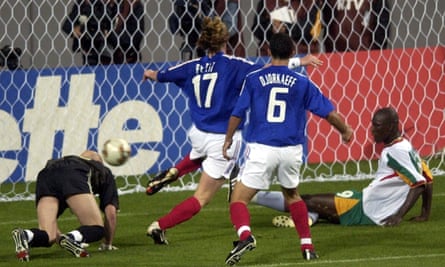 Senegal’s Papa Bouba Diop pushes the ball past France’s goalkeeper Fabian Barthez as Youri Djorkaeff and Emmanuel Petit arrive too late