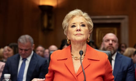 a woman in red sits behind a microphone
