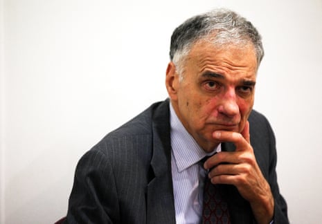 a man in a suit rests his chin on his hand