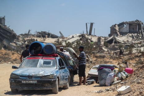 Displaced Palestinians fleeing northern Gaza load their belongings into a car before heading south as the Israeli military prepares to relocate people to the southern part of the territory, in Gaza City, 18 August 2025.