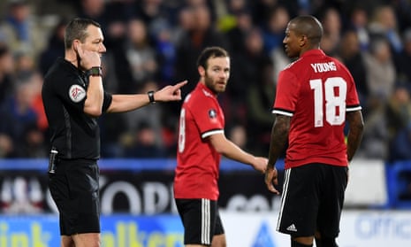 Kevin Friend consults with the Video Assistant Referee as Manchester United players await a decision over a Juan Mata goal.