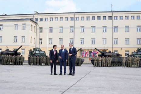 Rishi Sunak, left, Poland's prime minister Donald Tusk and Nato secretary general Jens Stoltenberg arriving together today at the Armourd Brigade barracks in Warsaw, Poland.