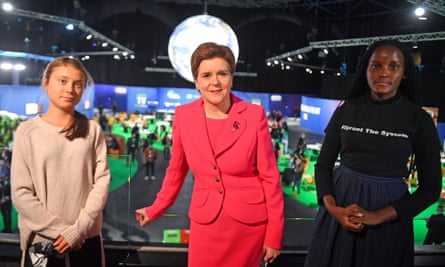 Nicola Sturgeon, Greta Thunberg and Vanessa Nakate in a hall at the conference; Sturgeon is in the centre and wears a bright red suit