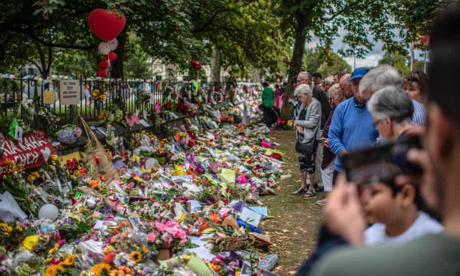 People view tributes left in Christchurch, New Zealand, after the mosque shootings. The Australian man accused of killing 51 worshippers, has changed his plea to guilty.