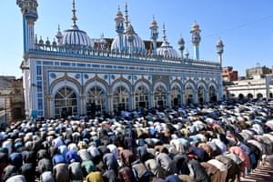 People pray in front of a grand building