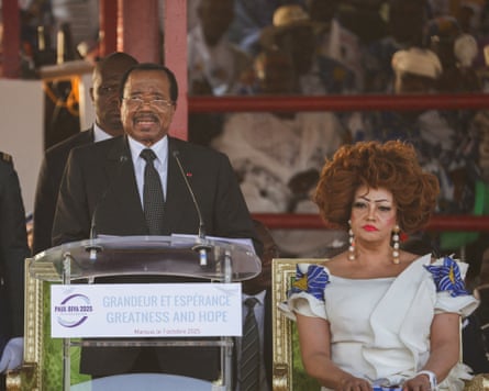 Paul Biya gives a speech with his wife, Chantal, on stage next to him