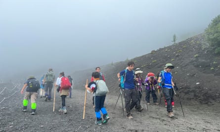 Groups of hikers passing each other on a misty section of the mountain