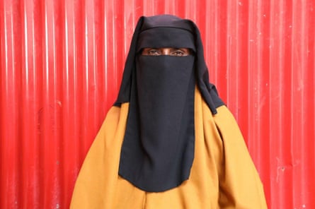 A female successful a achromatic niqab veil against a reddish metallic background
