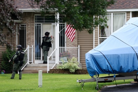 Police in tactical gear knock on a home