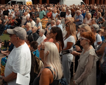 A crowd of people face towards a screen (off-camera)
