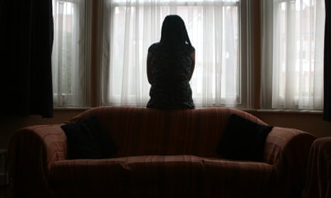 a young woman seen in silhouette at her window.
