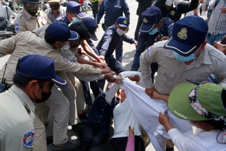 Police officers block relatives of the defendants outside Phnom Penh court, Cambodia, 14 June 2022.