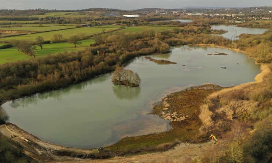 A marshland and a lake next to fields.