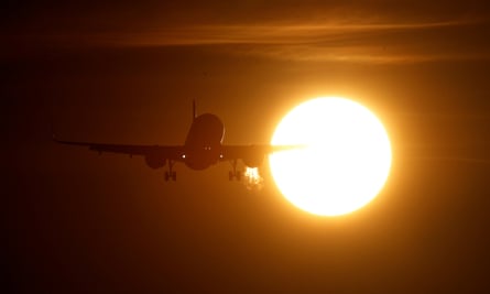 A plane is seen in front of the sun